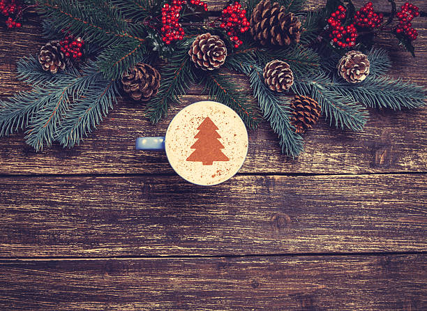 istock Cup of coffee with cream christmas tree on a table. 528364859