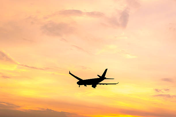 istock Silhouette of an aircraft flying in dramactic sunset sky 528365155