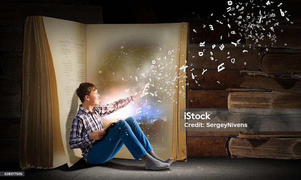 Guy reading book Teenager boy wearing jeans and shirt and reading book Child Stock Photo