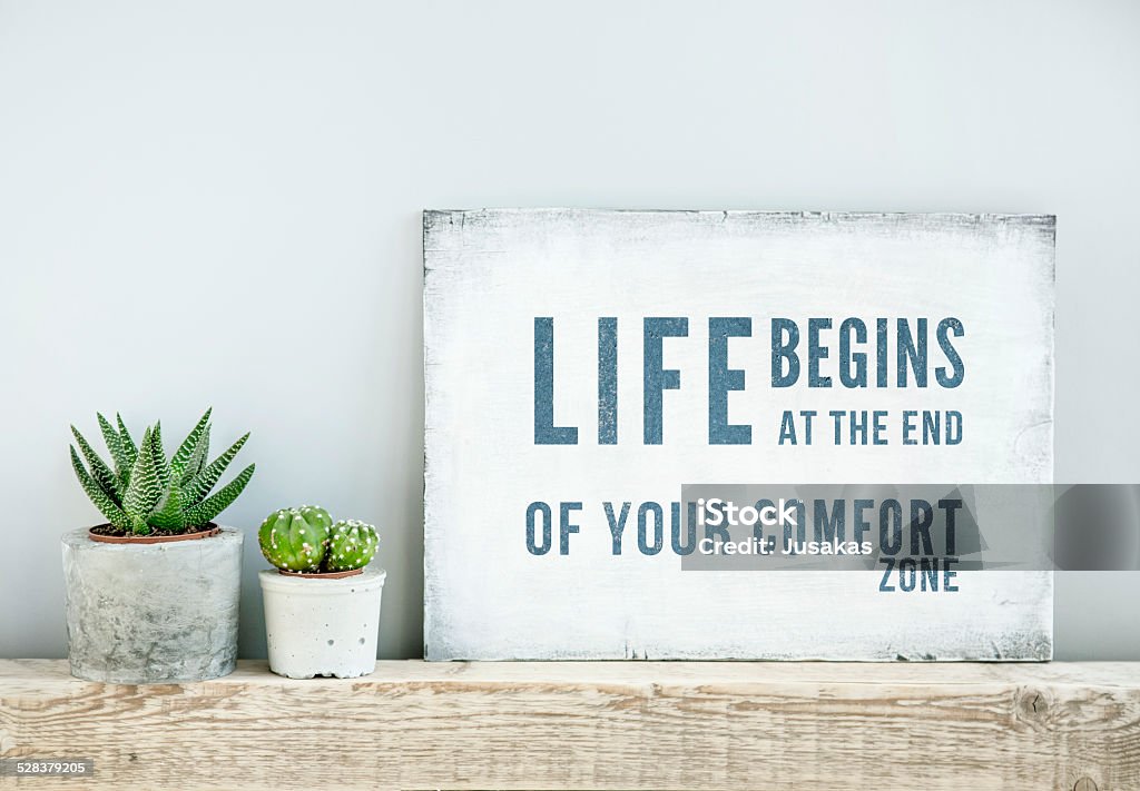 motivational quote LIFE BEGINS AT THE END OF COMFORT ZONE motivational poster quote LIFE BEGINS AT THE END OF COMFORT ZONE. scandinavian or american style room interior. Comfortable Stock Photo