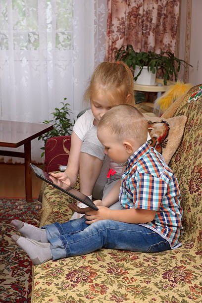 istock sister and brother with tablet 528393041