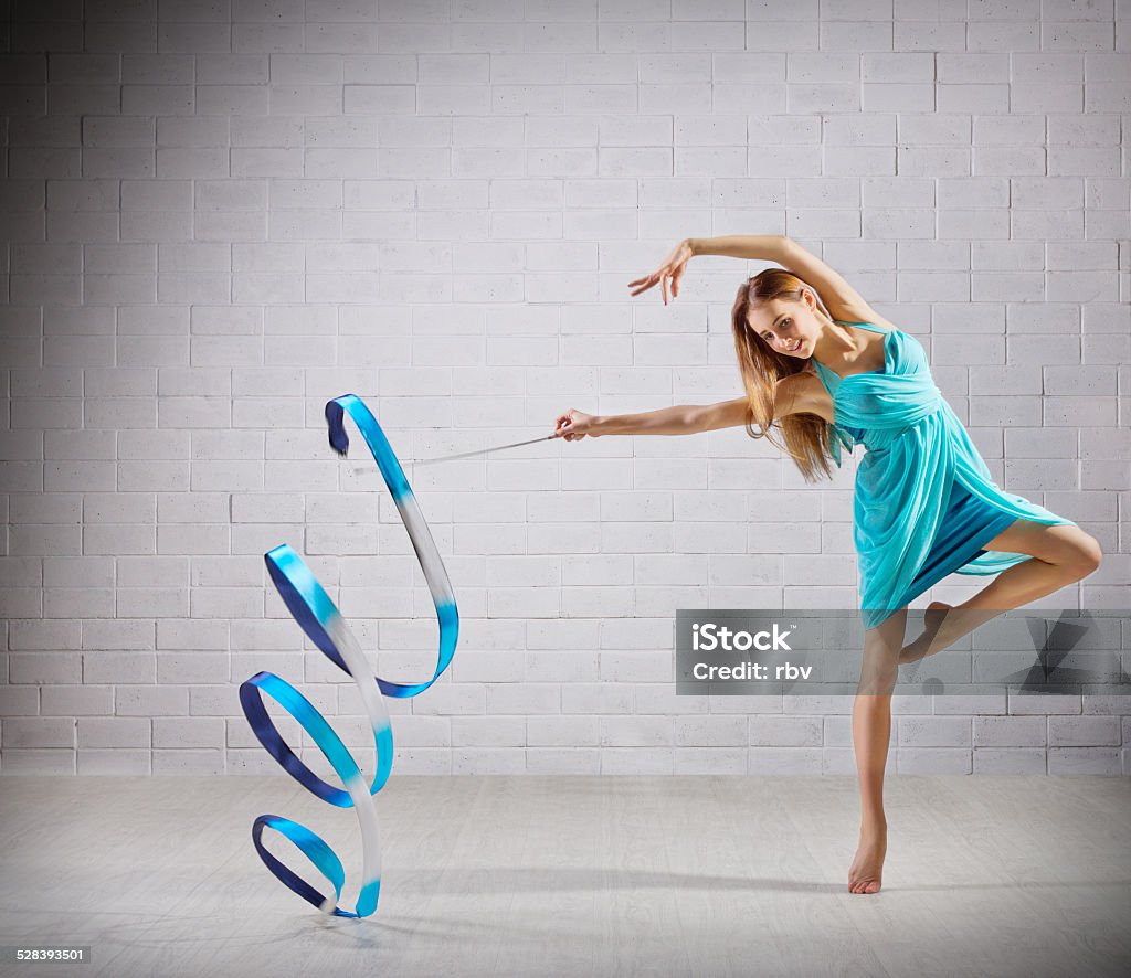 Girl is engaged in art gymnastics on grey wall Young girl is engaged in art gymnastics on grey wall Acrobat Stock Photo