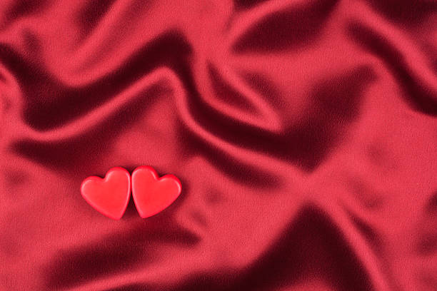 istock concept of two lovers hearts lying on the red satin 528395381