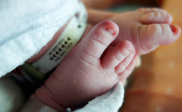 Newborn Baby Feet with Security Tags Nothing cuter than newborn baby feet. Shown here with hospital security tags. baby bracelet stock pictures, royalty-free photos & images