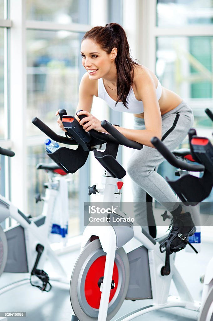 healthy woman riding a bike during exercising training Gym Stock Photo