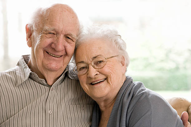 Elderly Man and Woman Sitting on Couch stock photo