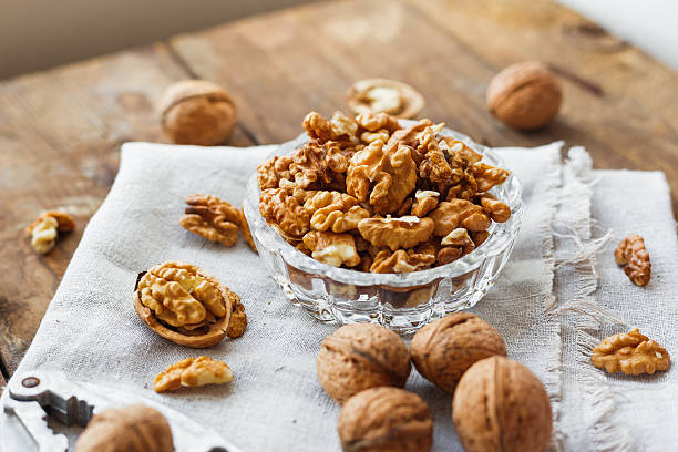 istock Glass bowl with walnuts on rustic homespun napkin. Healthy snack. 528416456