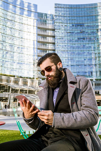 istock Stylish Hipster sitting outdoor with digital tablet 528417147