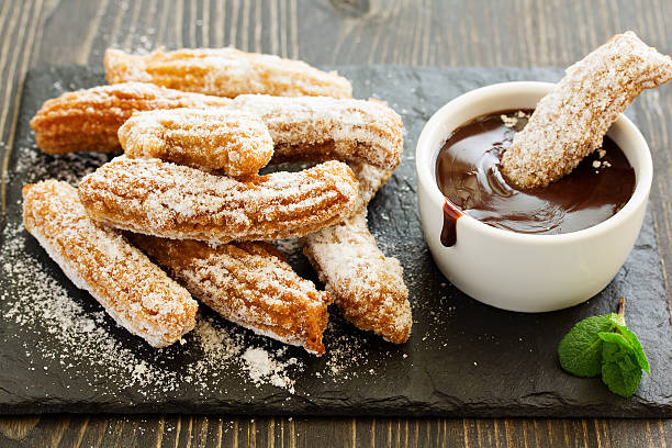 churros con chocolate caliente y azúcar en polvo. - churro chocolate cup sweet food fotografías e imágenes de stock