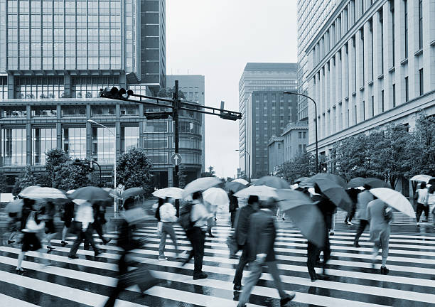 chuvoso trabalhadores na faixa de pedestres - umbrella parasol rain rush hour - fotografias e filmes do acervo