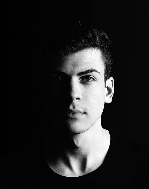 istock half-face young man portrait in low-key 528421132