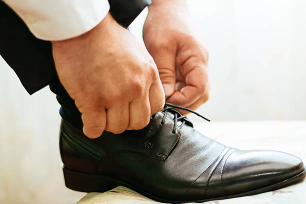 istock groom tying shoe laces 528422028