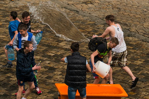 Lviv, Ukraine - May 2. 2016: Celebration pouring water on Monday after Easter by the town hall. Happy boys pouring water on each other.
