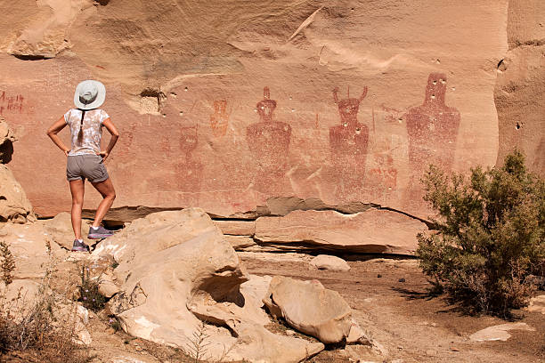 istock Woman admires Sego Canyon vandalized rock art panel Utah 528423074