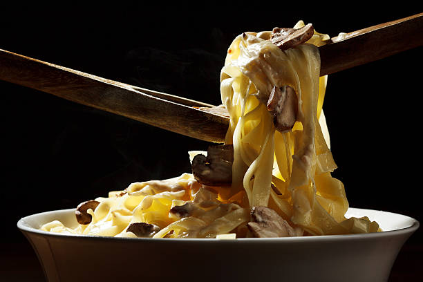 istock Hot steamed pasta on black background 528423422
