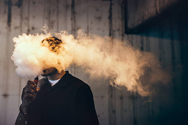 man using an electric cigarette - vape stockfoto's en -beelden