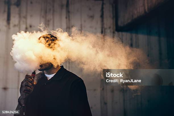 Man Using An Electric Cigarette Stock Photo - Download Image Now - Electronic Cigarette, Electronic Cigarette Smoke, Men