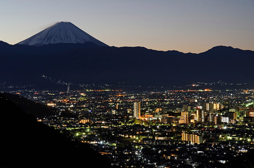 Kofu city photographed from high point view during twilight with Mt. Fuji in the background. ( winter season )