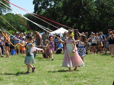 Austin, TX, USA - April 30, 2016: Girls walk around a maypole at Eeyore's Birthday Party, an annual hippie festival that began in 1963.