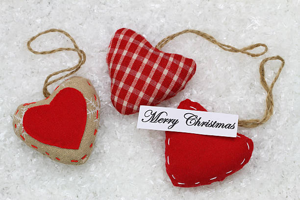 istock Merry Christmas card with three red hearts on snowy surface 528426501