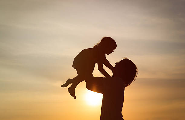 istock Father and little daughter silhouettes at sunset 528426726
