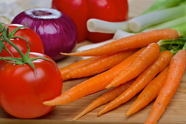 istock Carrots and tomatos on a wooden table 528427161