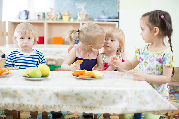 istock Funny kid kissing another one in day care centre 528429702