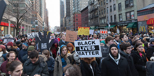 Protest in New York New York, NY USA - December 13, 2014: Angry protesters march against police brutality and grand jury decision on Eric Garner case on 6th Avenue marching photos stock pictures, royalty-free photos & images