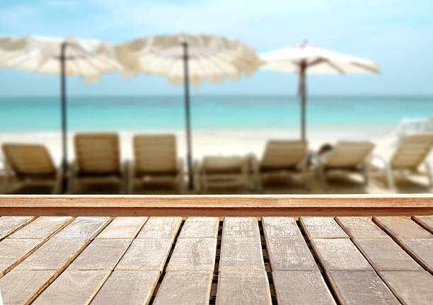 istock Wood table top on blurred blue sea and white sand 528430432