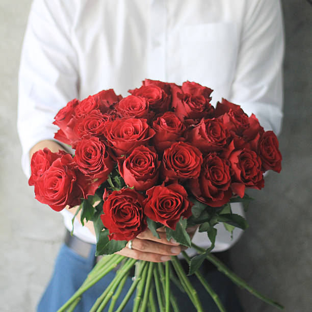 uomo con rose rosse. - rose valentines day bouquet red foto e immagini stock