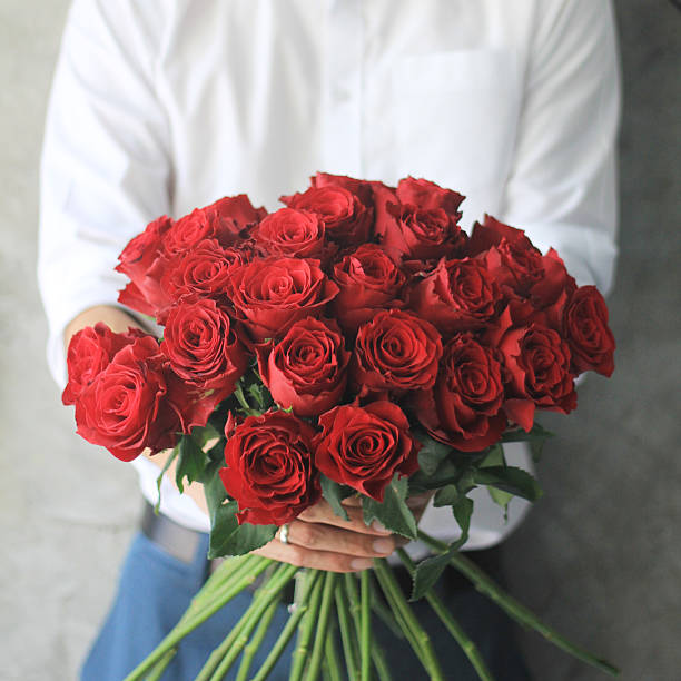 homem segurando rosas vermelhas. - rose valentines day bouquet red - fotografias e filmes do acervo