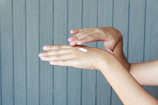 istock Young woman applying hands cream 528434116