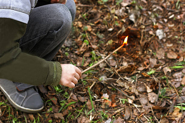 istock Child sets fire to the foliage. 528435238