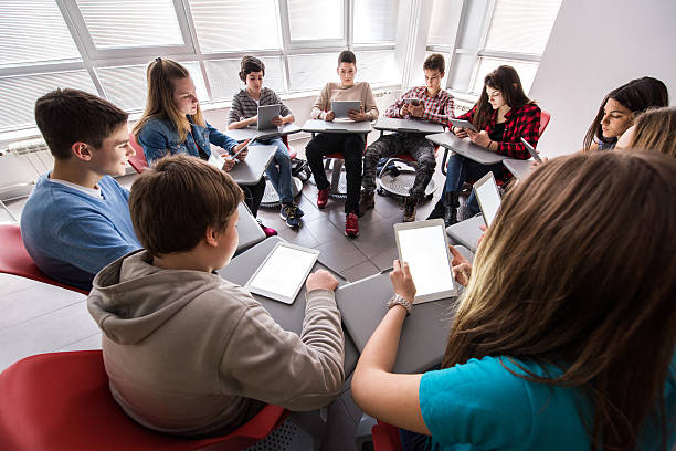 studenti delle scuole superiori utilizzando digitale tablet in un cerchio. - teenage boys teenager teenagers only adolescence foto e immagini stock