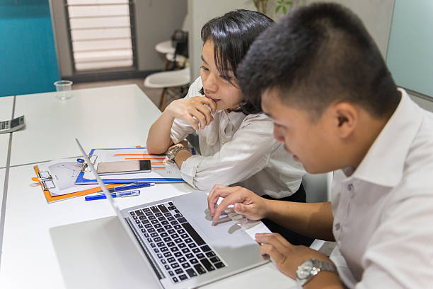 dois trabalhadores discutir a todos os outros as informações no computador portátil - job search note pad business person interview - fotografias e filmes do acervo