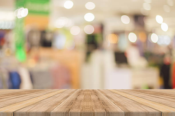 istock Wooden board empty table blur in department store background. 528436912