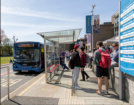 Swansea, UK: May 4, 2016:  Swansea University has two campuses. The Singleton Park Campus is set in the grounds of Singleton Park to the west of Swansea city centre. Students are waiting for a bus. 