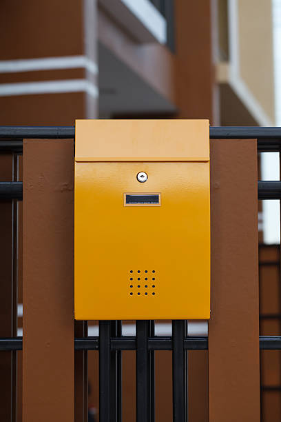 istock yellow mailbox on brown fence 528438397