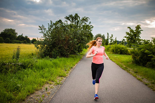 istock Young woman running outdoors in a city park 528439320