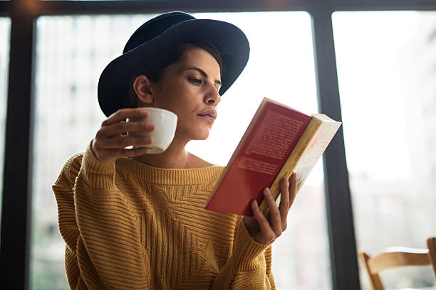 istock Young woman reading a book and drinking coffee. 528439774