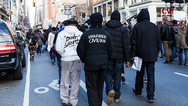 Protest in New York New York, NY USA - December 13, 2014: Protesters march against police brutality and grand jury decision on Eric Garner case on 6th Avenue police brutality photos stock pictures, royalty-free photos & images