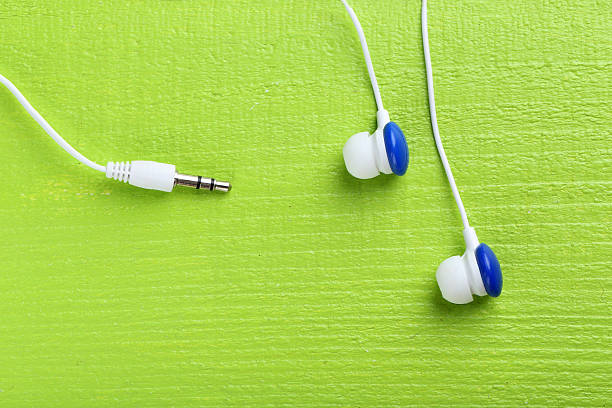 istock White headphones on a green wooden table 528441138