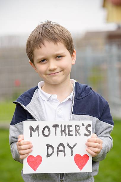istock Boy holding a greeting card for his mother 528441326