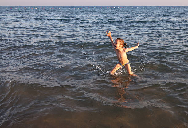 istock Joyful child jumps out of the sea. 528441671