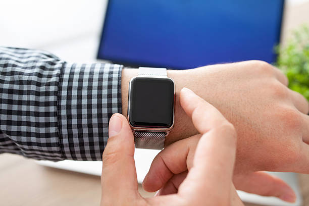 istock man hand holding a Watch on the background of laptop 528441912