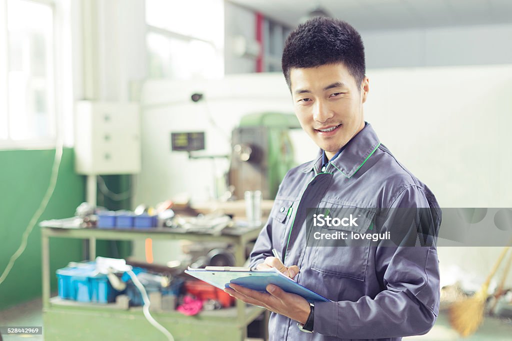 workshop manager writing daily report in the workshop Adult Stock Photo