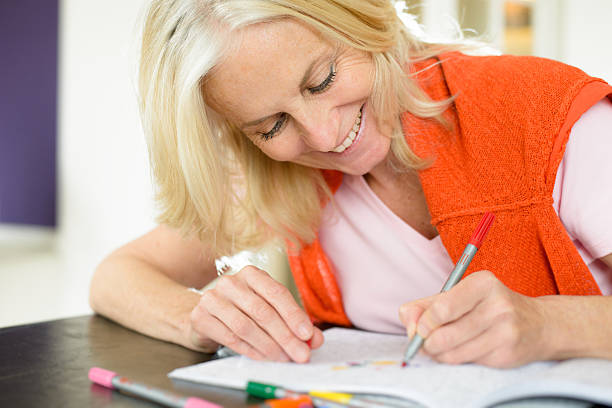 istock Mature Woman Enjoying Adult Colouring Book 528444018