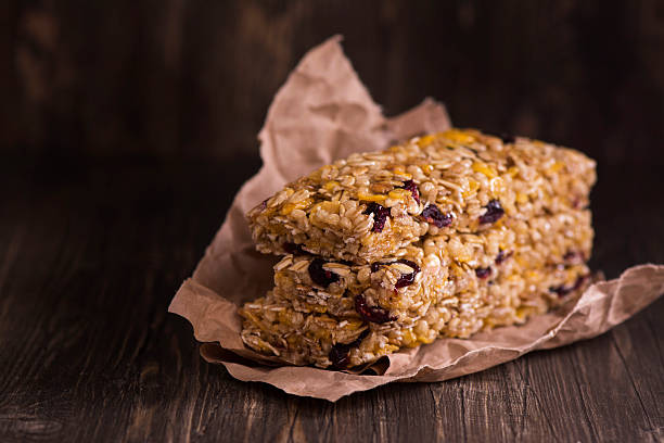 granola bar con ingredientes sobre una mesa de madera - protein bar cereal oat cranberry fotografías e imágenes de stock