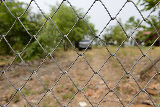 istock Wire mesh fence with blur farm background 528445926