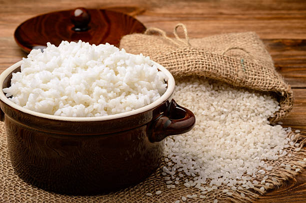 istock Boiled white rice in ceramic pot on wooden background. 528446376
